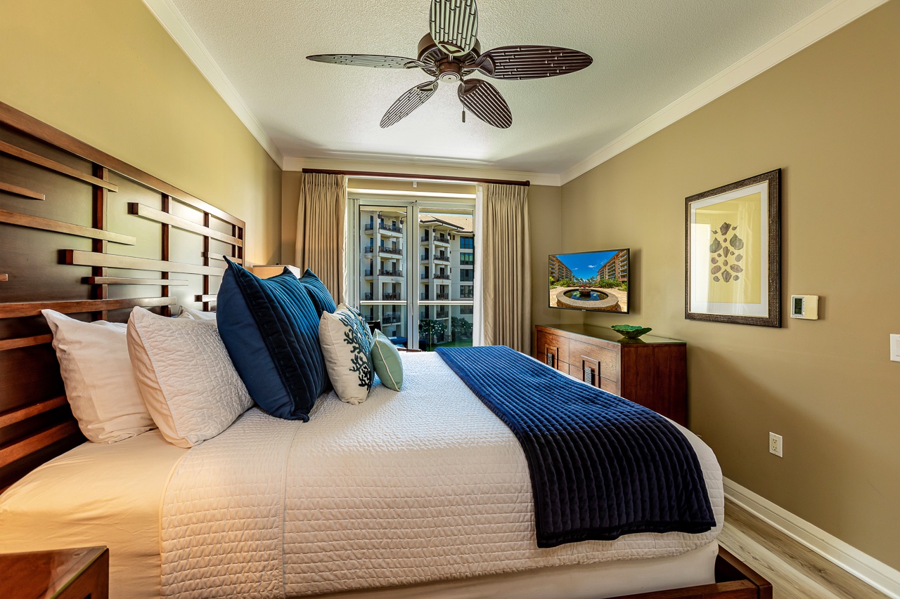 Drift off in this serene bedroom with its plush bedding and coastal touches. The balcony invites gentle breezes, while the ceiling fan keeps your nights cool and comfortable.