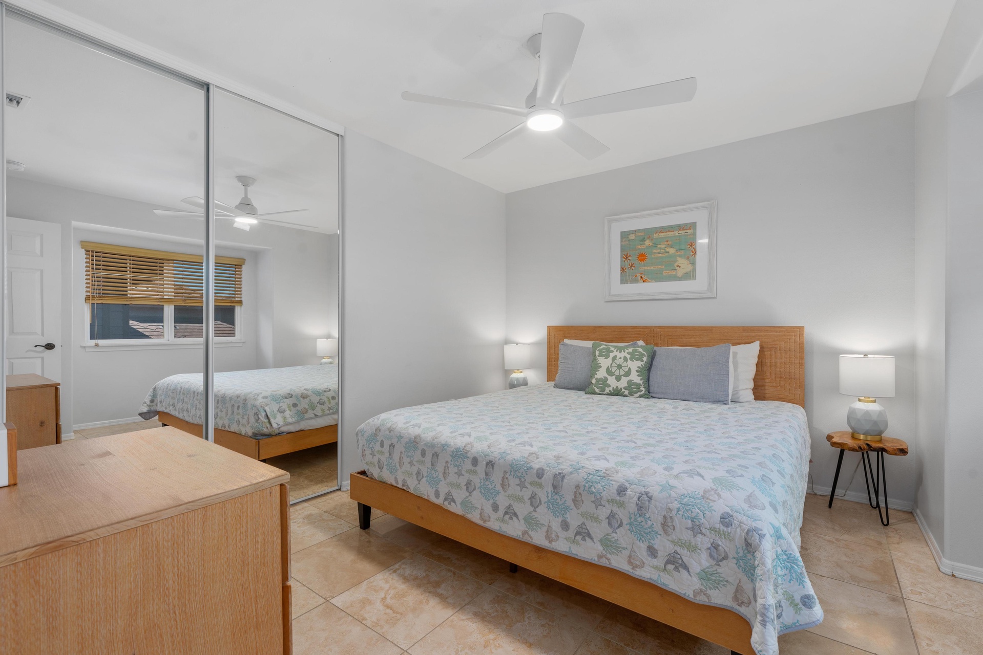 Unwind in your serene bedroom featuring coastal bedding and natural light streaming through bamboo blinds.