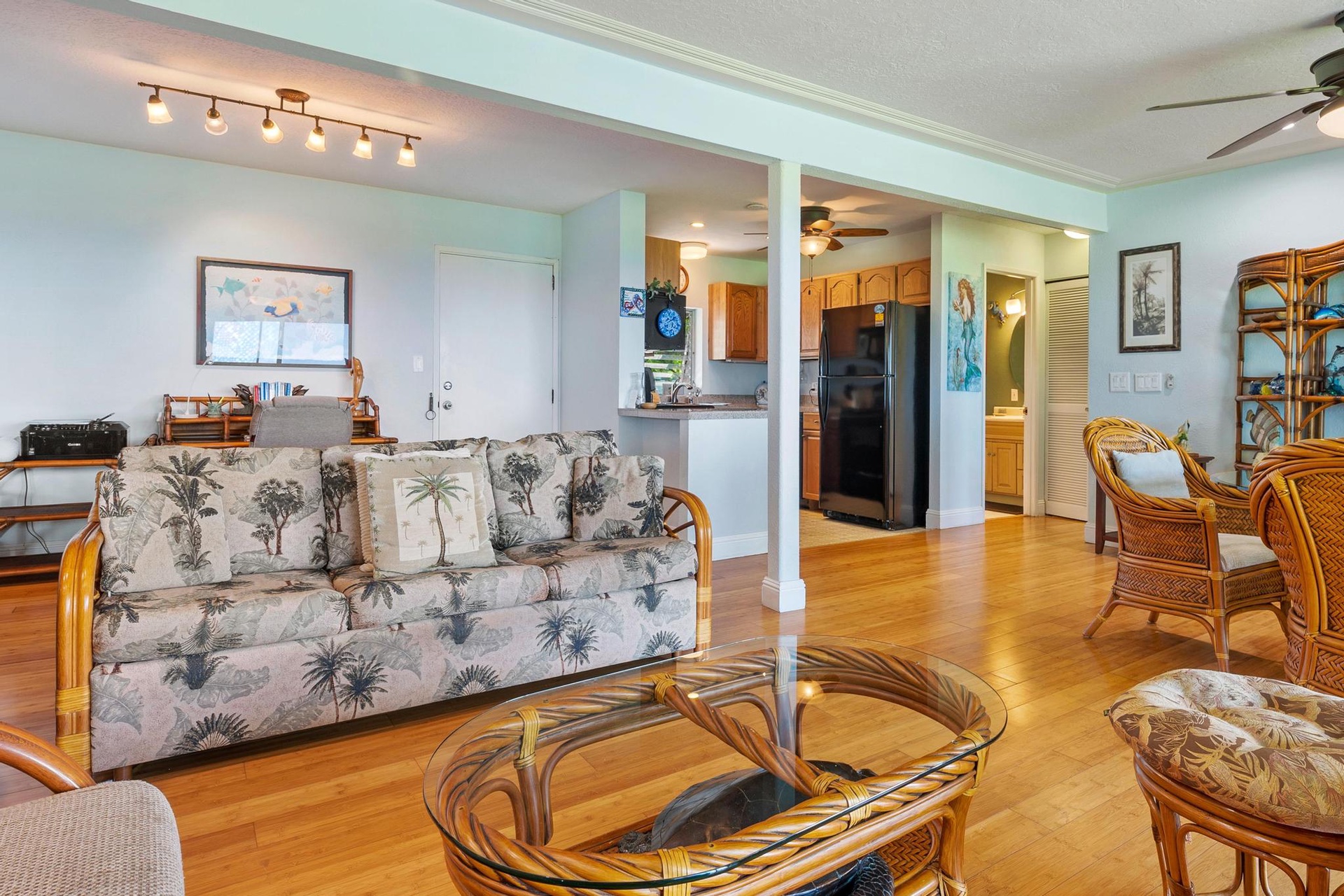 Relax in your tropical-themed living room with bamboo furniture and palm-print accents, while enjoying the open flow to your fully equipped kitchen.