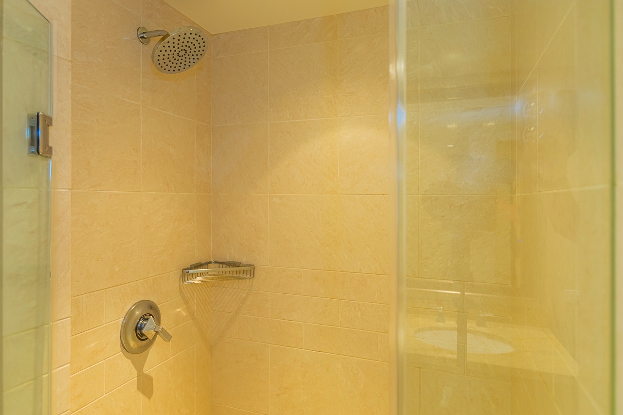 Refresh after your adventures in a spacious walk-in shower featuring an elegant rainfall showerhead, spa-style controls, and pristine tiled walls.