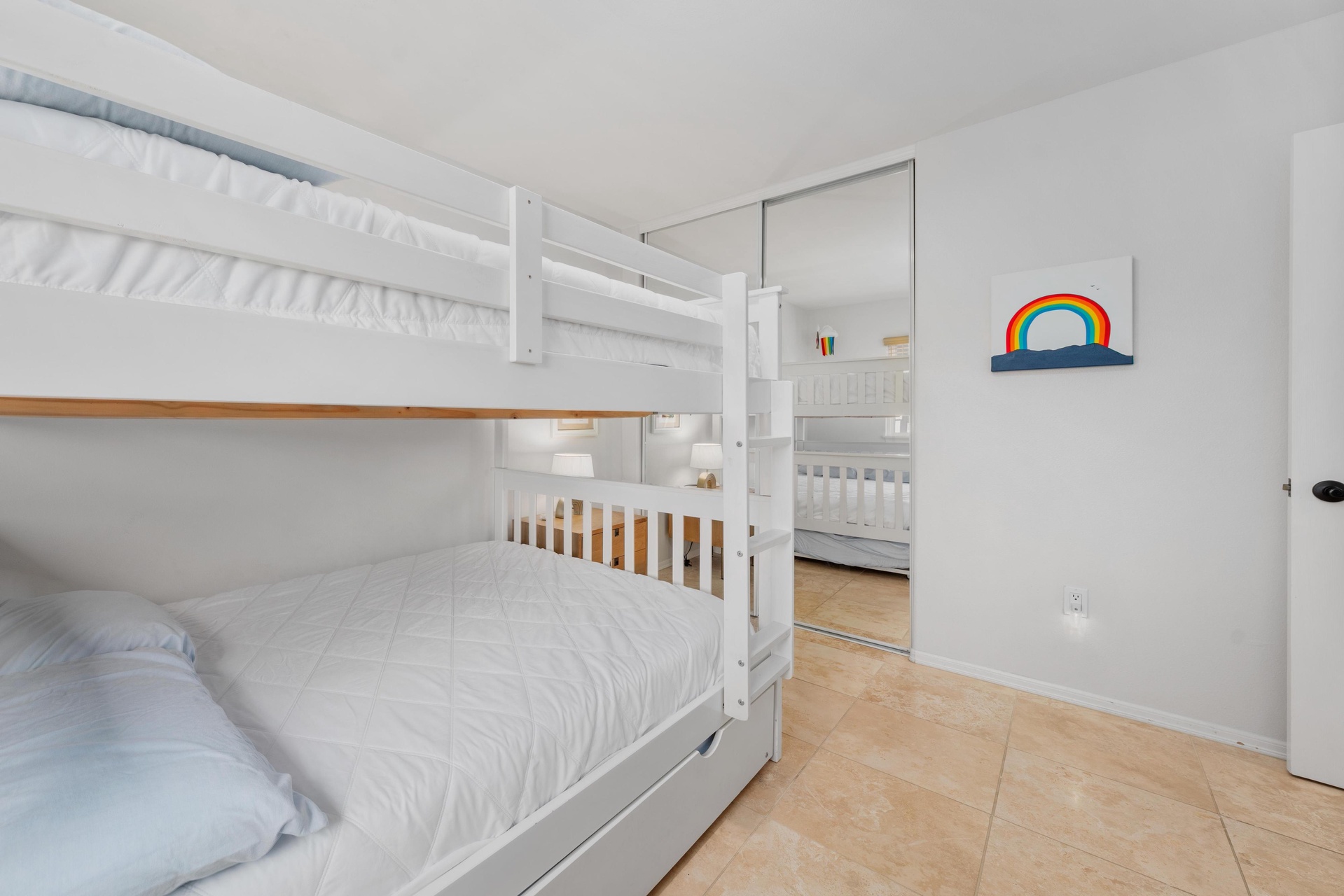 Your kids will love this bright bedroom with sturdy bunk beds and cheerful rainbow art—perfect for restful nights after beach adventures.