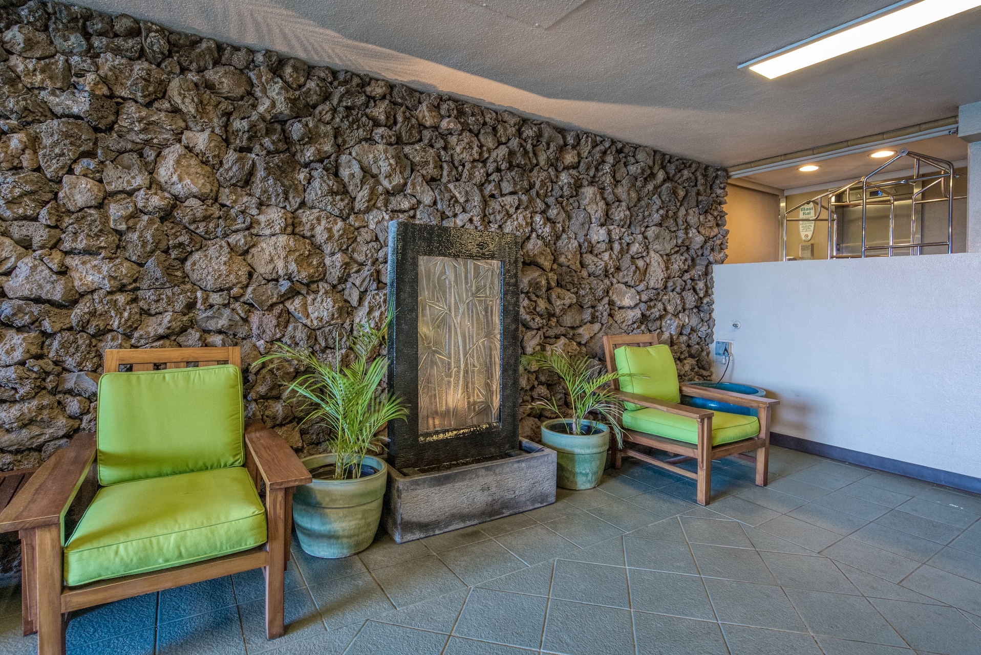Step into a tranquil space where natural stone meets tropical comfort, inviting you to pause and soak in the soothing sounds of the wall fountain.