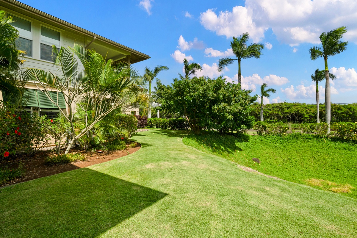 Tropical property surrounded by lush landscaping with palm trees and manicured gardens under sunny Hawaiian skies.