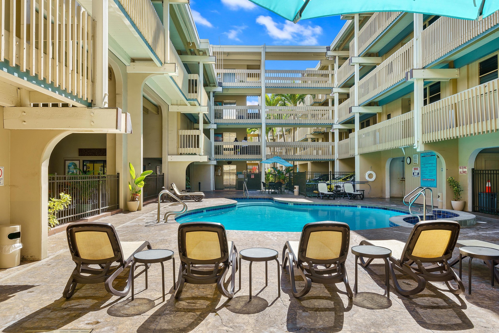 Bask in the sun by the sparkling pool, surrounded by tropical palms and colorful umbrellas, where loungers invite you to unwind in your own private courtyard retreat.