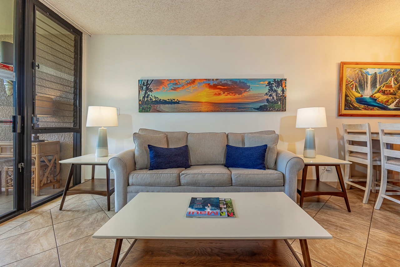 Unwind in your airy living space with a cozy sofa and vibrant coastal artwork.