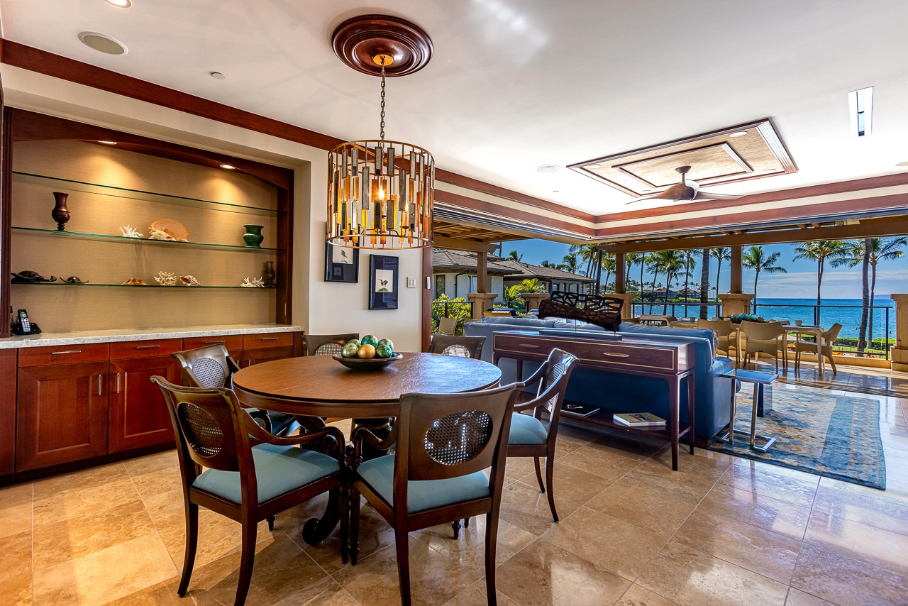 Your elegant dining area opens to a breathtaking oceanfront terrace, with palm trees swaying and waves just steps away.