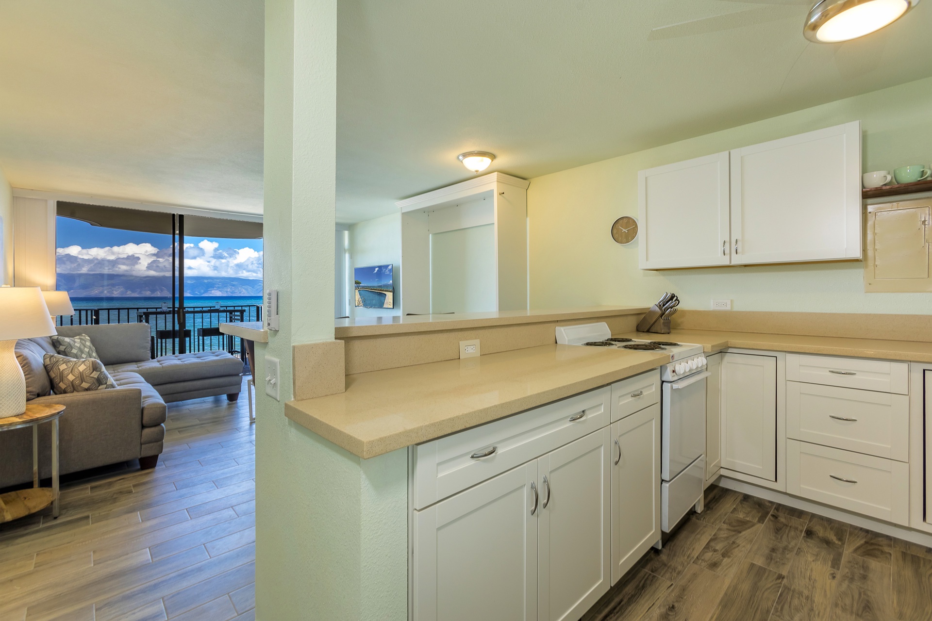 Cook your favorite meals in this well-equipped kitchen while glimpsing stunning ocean views. The open layout connects you to the living space and lanai beyond.