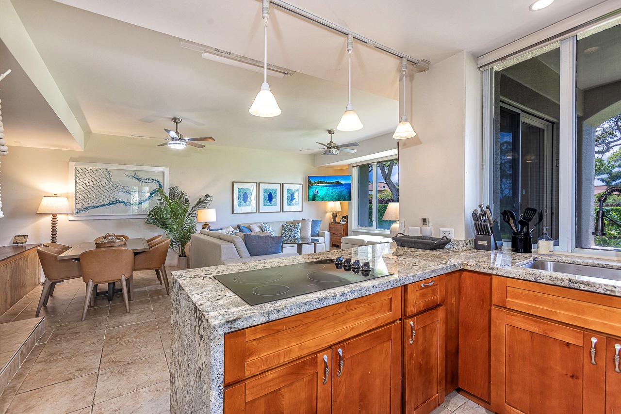 Step into your open-concept retreat with a modern kitchen, granite countertops, and coastal décor flowing into a bright, airy living space designed for relaxation and togetherness.