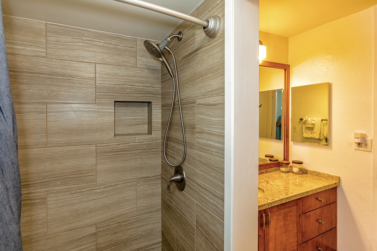 Guest bathroom has a walk in shower and separate vanity area.