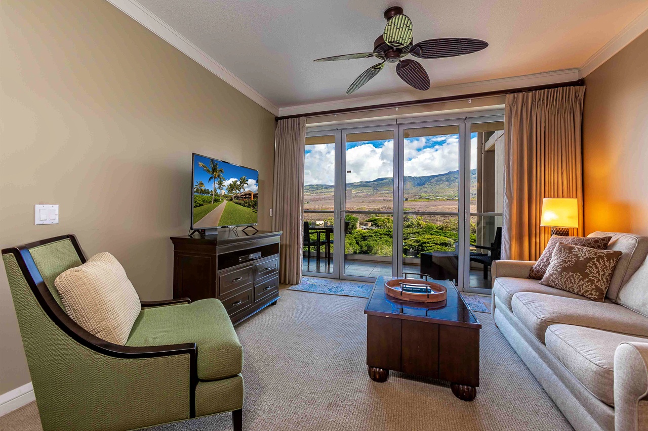 Step into your bright living room where soft seating and thoughtful details await. Through the glass doors, your private balcony opens to sweeping mountain vistas—perfect for morning coffee or watching the clouds drift by.