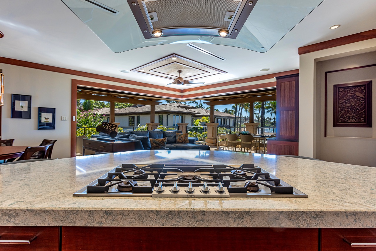 Cook with ease on your professional gas range while enjoying views of lush gardens and relaxing outdoor lounges. The open kitchen flows seamlessly to your private lanai and pool area beyond.