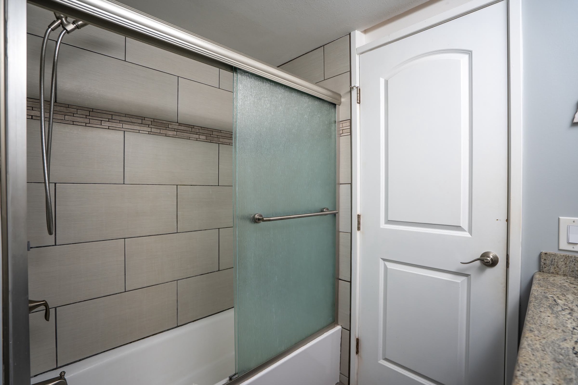 Step into your beautifully renovated bathroom with sleek, modern tile and a frosted-glass shower door that brings spa-like privacy and style.