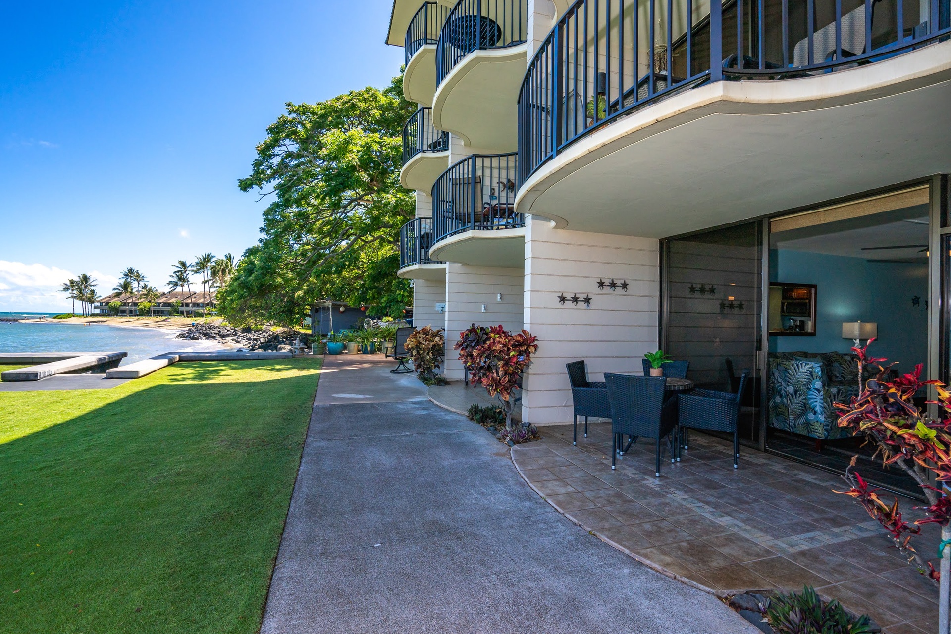 Step onto your own covered patio with oceanfront seating, where palm-studded shores and serene blue waters invite you to unwind just steps from the beach.
