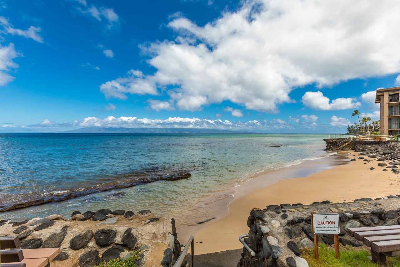 Peaceful beachfront location with golden sand, turquoise waters, and dramatic cloudscapes stretching endlessly across the horizon, offering a serene oceanside escape.