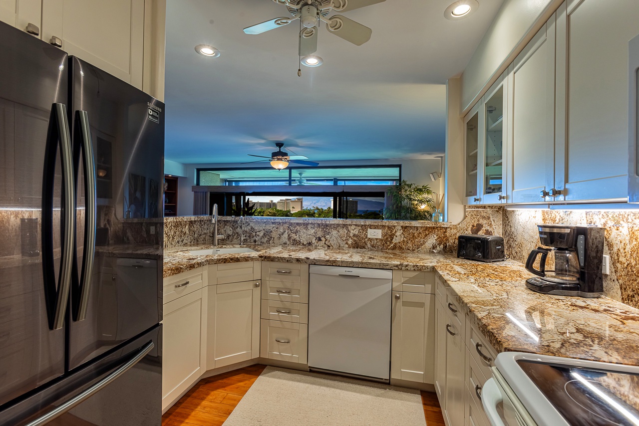 Gourmet kitchen with granite countertops, stainless steel appliances, and warm under-cabinet lighting.