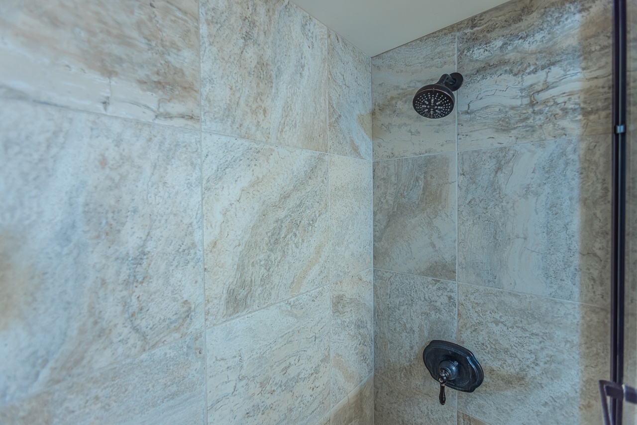 Indulge in your private marble sanctuary with rainfall showerhead and premium fixtures for the ultimate spa experience.