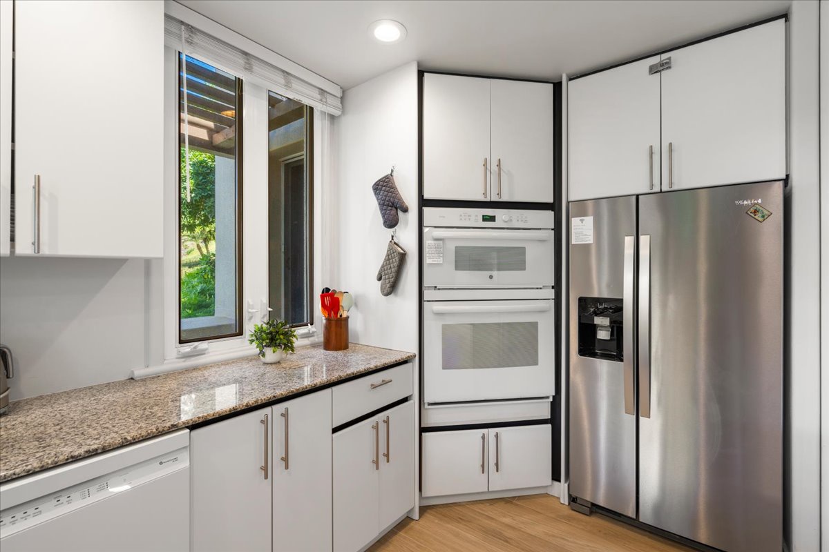 Step into your fully equipped kitchen where gleaming countertops and modern appliances await. Natural light streams through the window, creating a bright space for preparing your favorite meals.