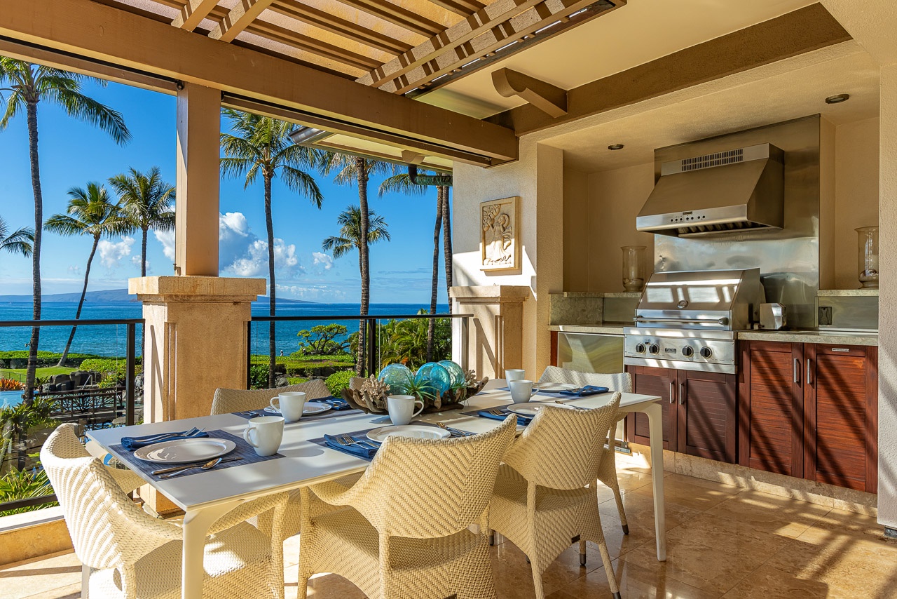 Dine al fresco in your covered outdoor kitchen, where ocean breezes and swaying palms frame stunning blue water views. The built-in grill and dining table make island-style entertaining effortless.
