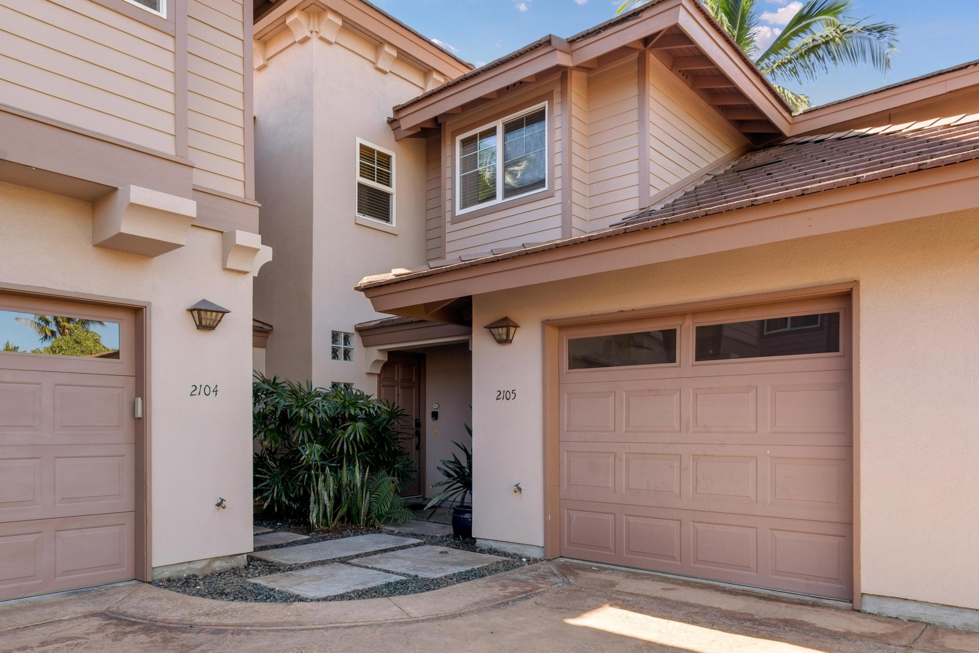 Well-appointed property exterior with tropical landscaping welcomes guests to a comfortable vacation home.