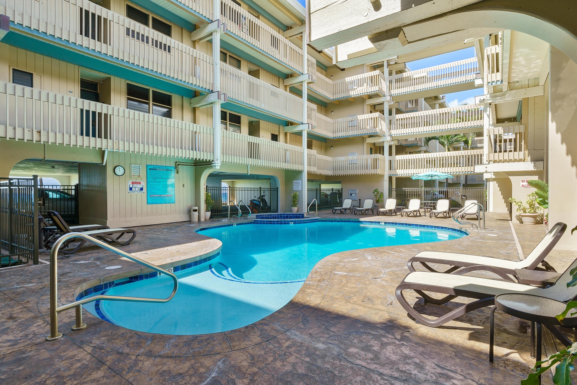 Picture yourself lounging poolside, soaking up the sun surrounded by balconies and tropical vibes, your perfect vacation relaxation spot.