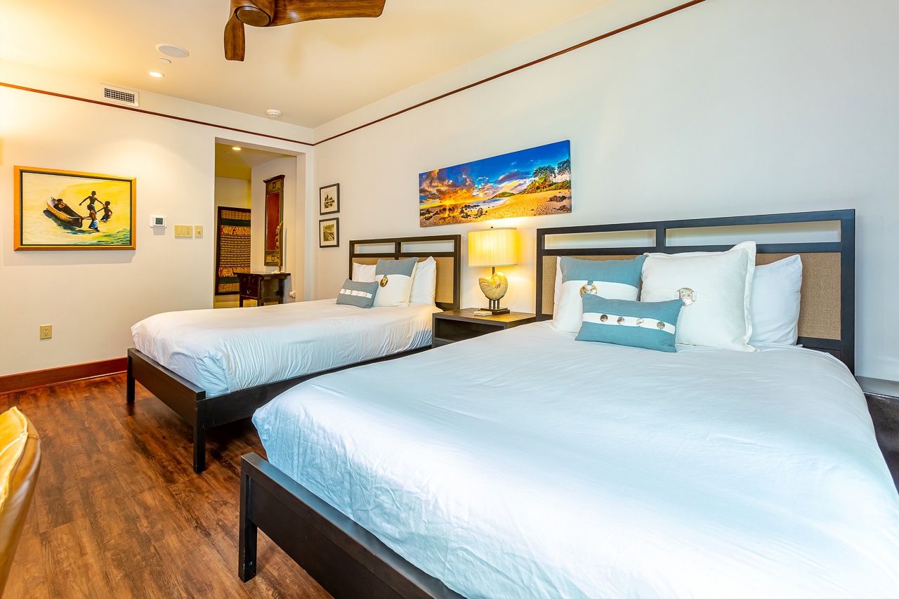 Rest easy in this bright, tropical-inspired bedroom with plush bedding and cheerful coastal artwork to welcome you after a day of adventure.