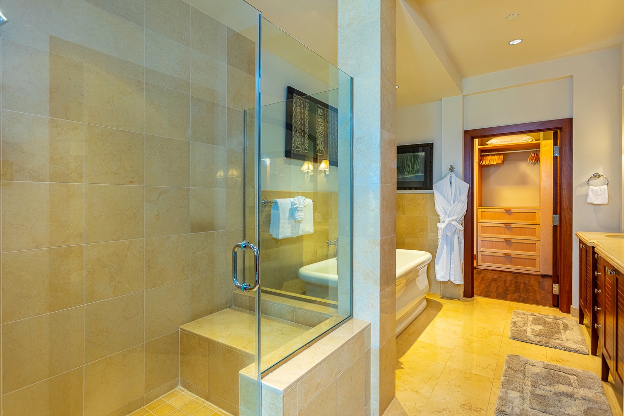 Step into your luxurious spa-like bathroom with a sleek glass-enclosed shower, soaking tub, plush robe awaiting, and custom vanity—your private retreat for ultimate relaxation.