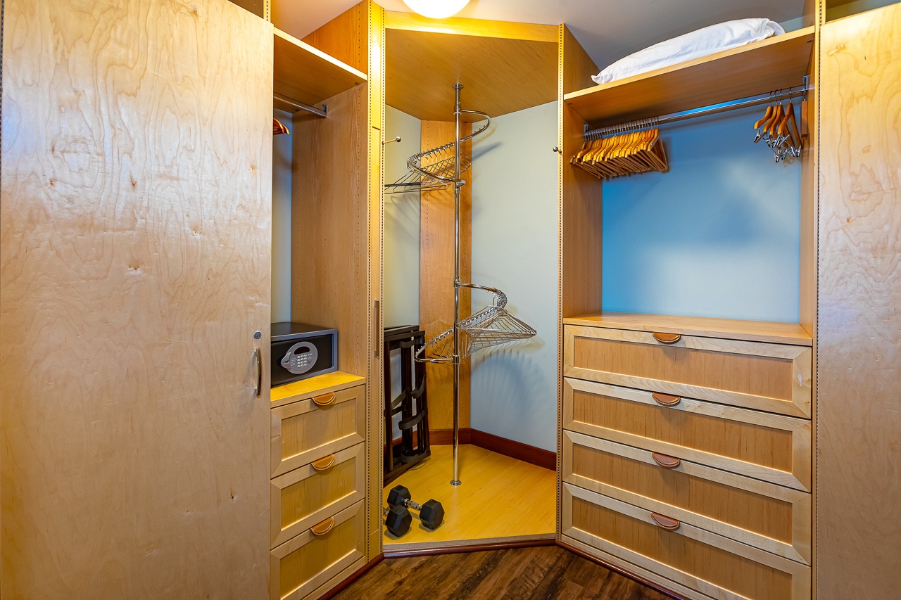 Store your belongings in this well-organized closet with ample hanging space, built-in drawers, and a secure safe for valuables.