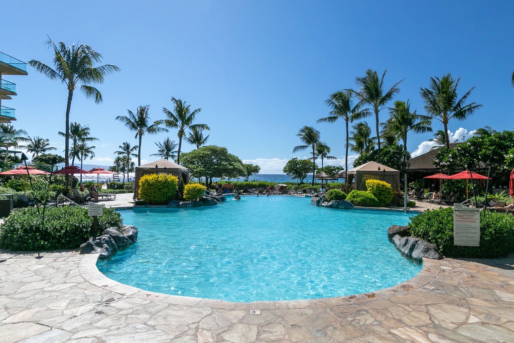 Lounge chairs and shaded seating invite all-day relaxation under the warm Hawaiian sun.