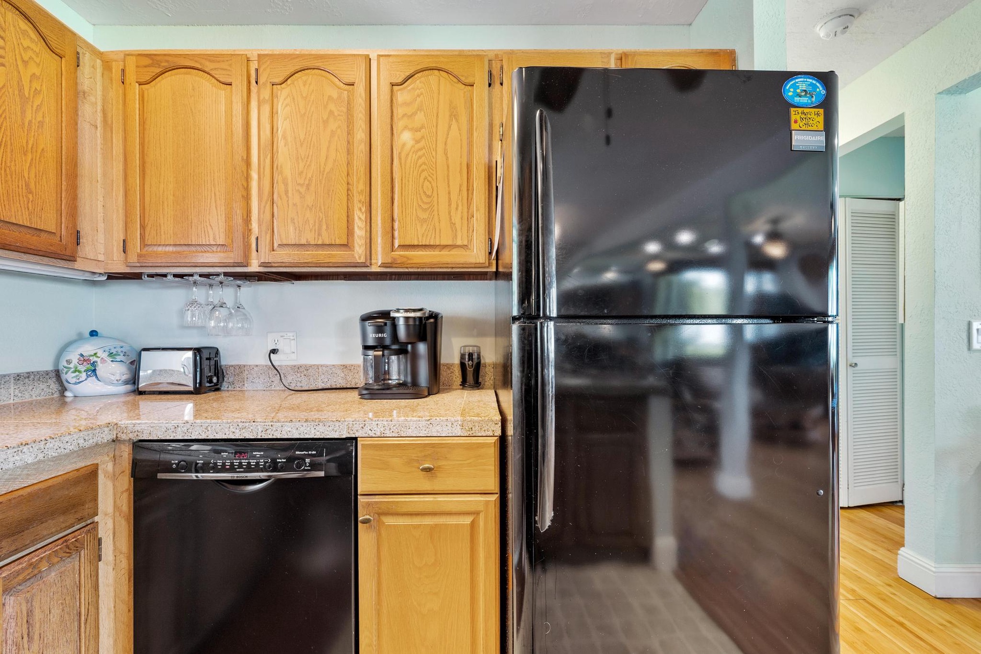 Your fully equipped kitchen features warm wood cabinets, granite counters, and modern black appliances for all your culinary adventures.