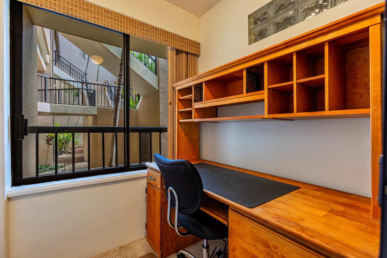 Your dedicated workspace awaits, complete with a built-in desk and ample storage cubbies, bathed in natural light from the courtyard view.