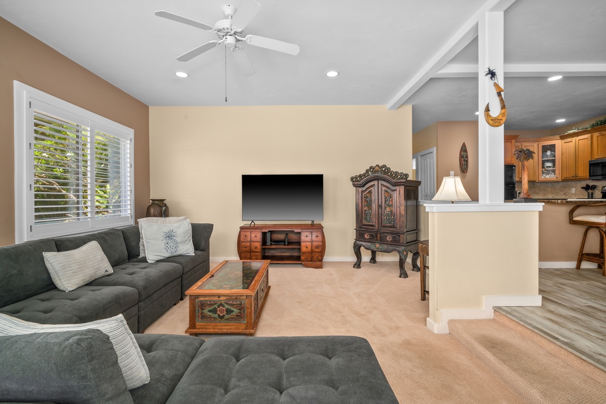 Unwind on plush sofas beneath a cooling ceiling fan, with your favorite shows on the big screen. Natural light and an open layout.