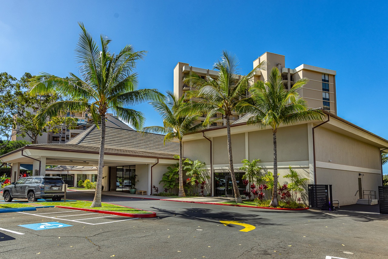 The property entrance is framed by swaying palms and lush greenery, welcoming you to your tropical island retreat.