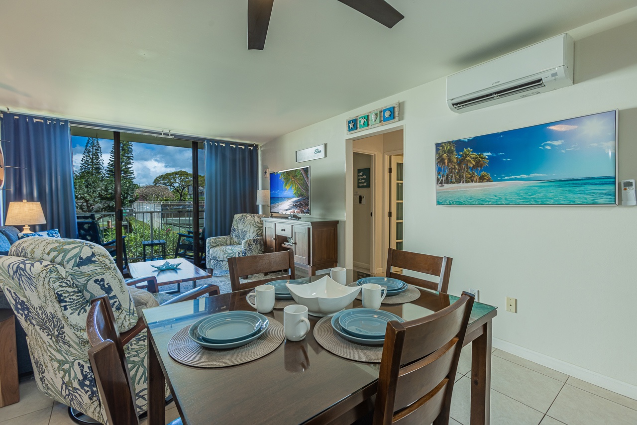 Your open living space flows seamlessly from dining to relaxation, with tropical artwork and garden views creating an island escape feeling.