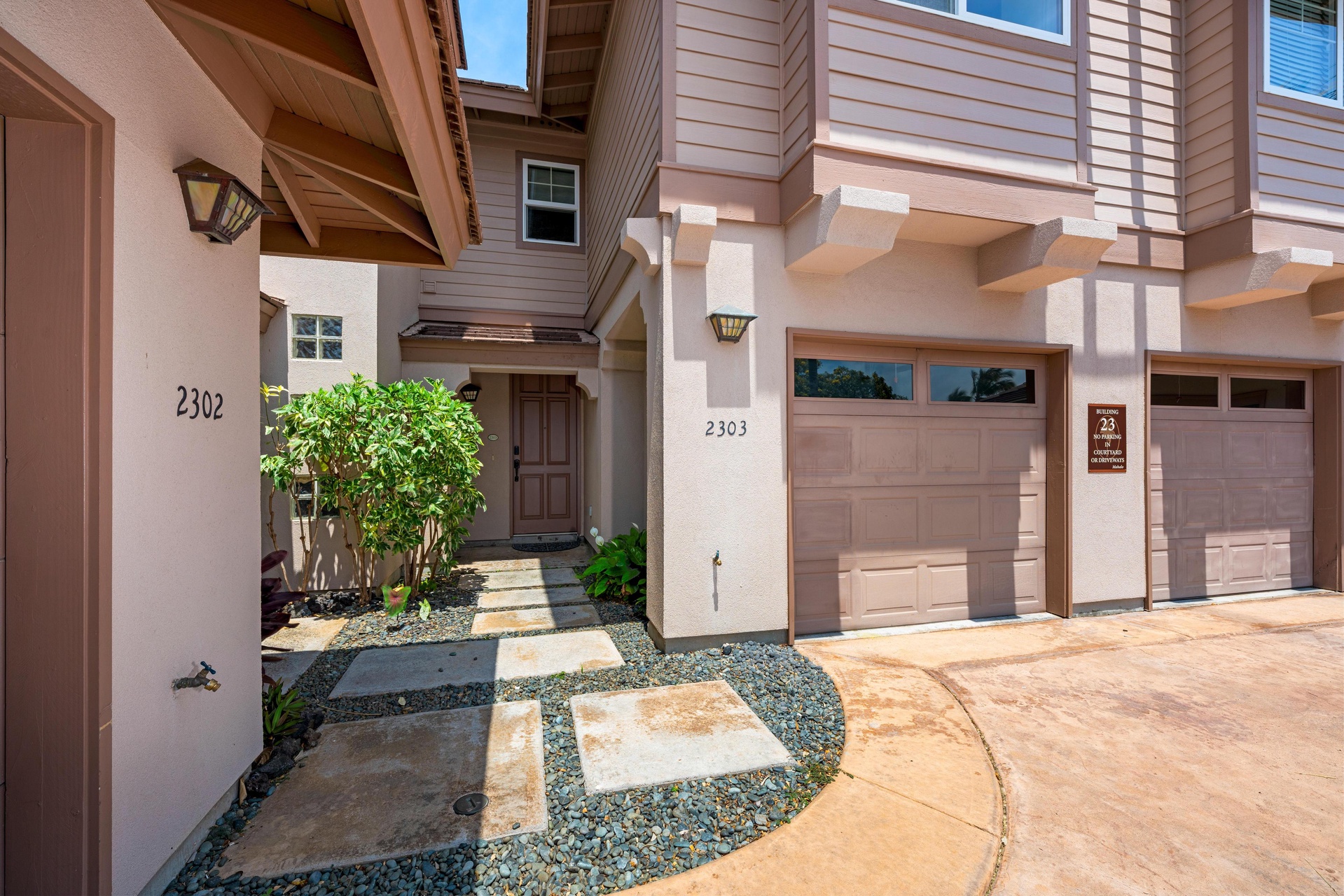 Modern townhome with covered entry, private garage, and contemporary landscaping welcomes guests to this stylish retreat.