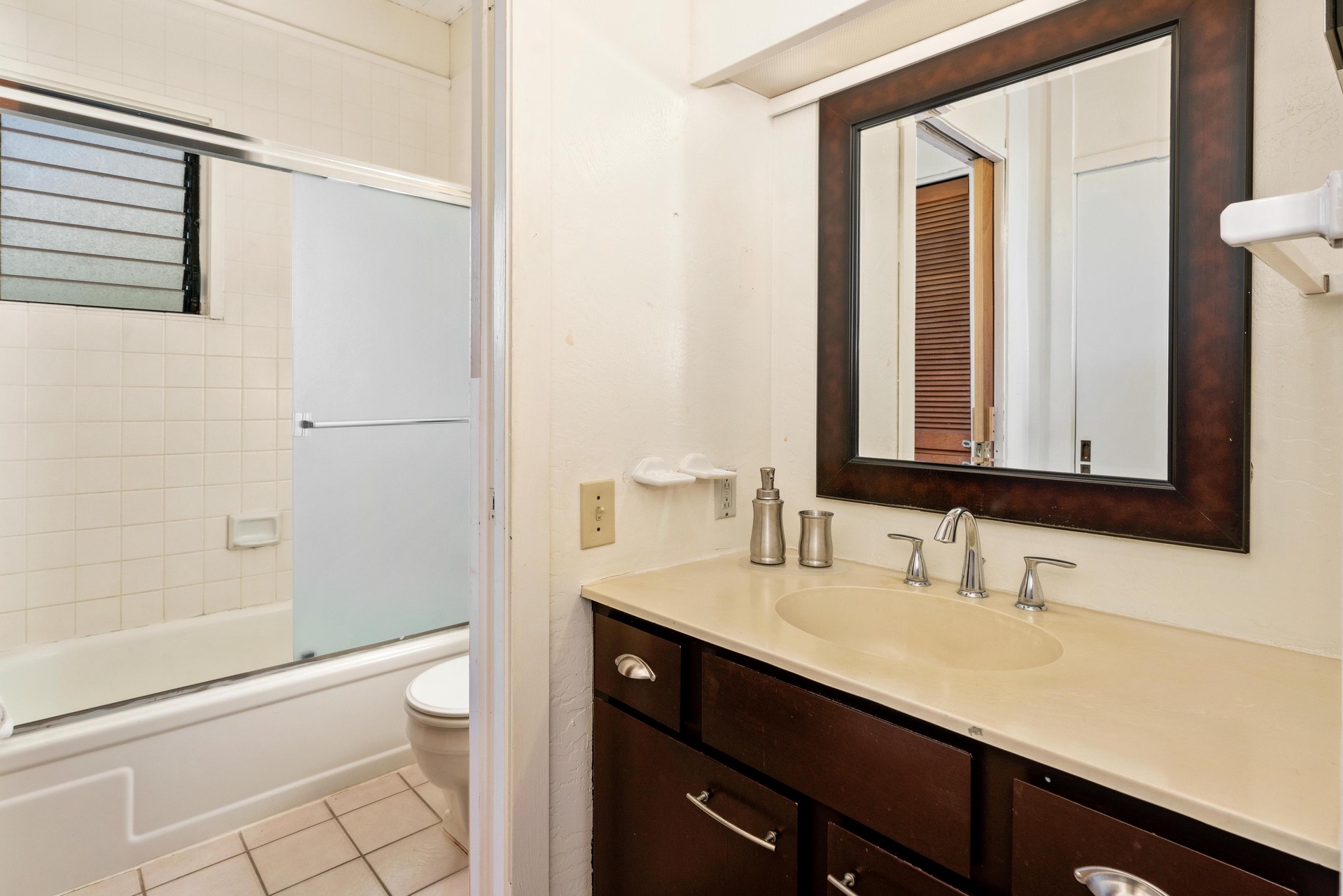 Freshen up in your private bathroom featuring a bathtub-shower combo and stylish dark wood vanity, perfect for unwinding after a day of adventure.