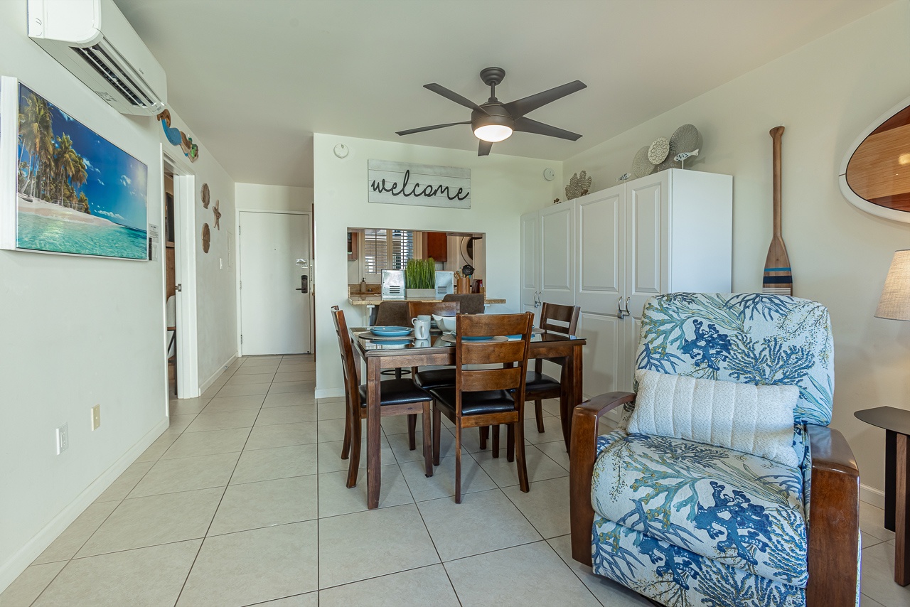 Relax in your coastal-themed living space with tropical blue accents, where the ceiling fan keeps you cool as you dine and unwind.