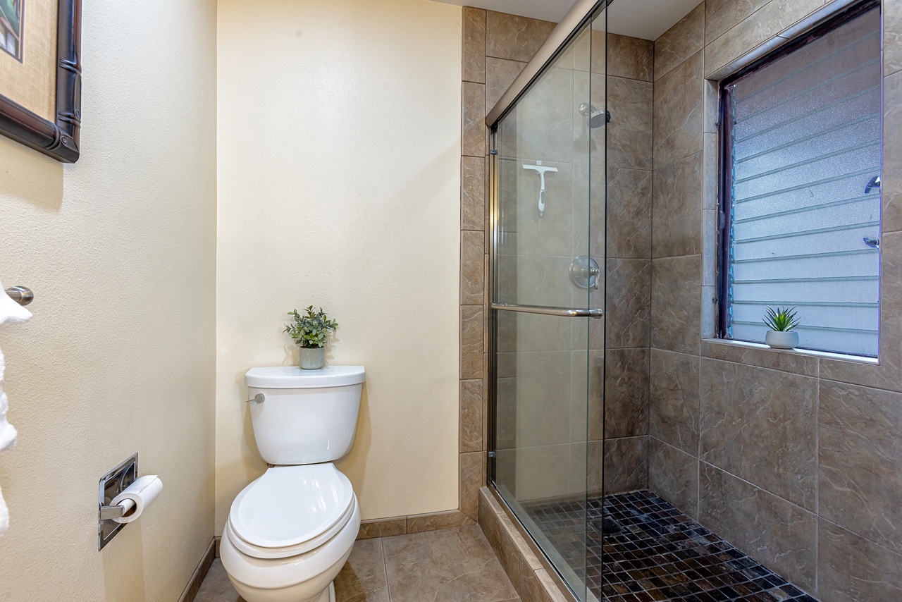 Step into your beautifully tiled bathroom, where a spacious glass-enclosed shower and modern fixtures invite you to refresh and unwind in style.
