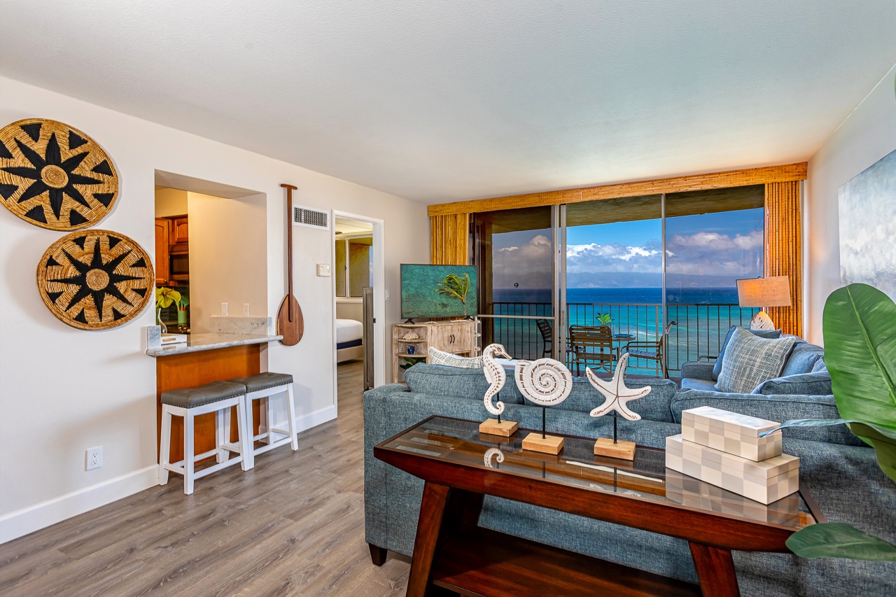 Watch the ocean sparkle from your oceanfront balcony while relaxing in this stylish living room, where coastal décor and tranquil blue hues create your perfect island escape.