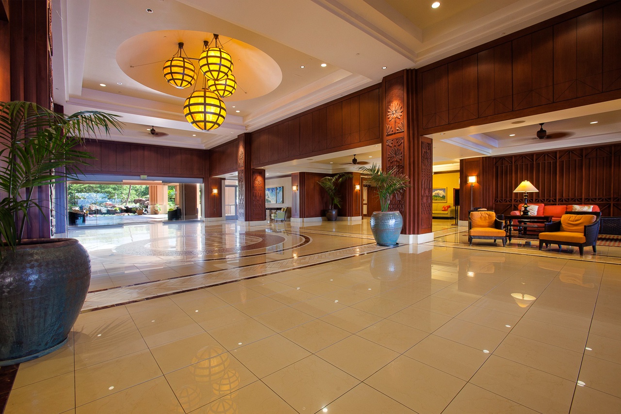 Step into an inviting lobby adorned with warm wood paneling, elegant pendant lighting, and tropical accents. The spacious design welcomes you with gleaming floors and comfortable seating areas perfect for relaxing after your adventures.
