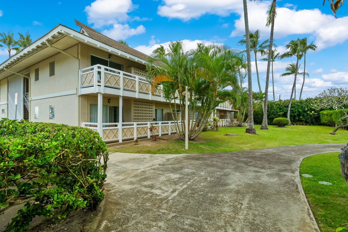 A tropical vacation retreat surrounded by swaying palms and manicured lawns with private balconies overlooking lush gardens.
