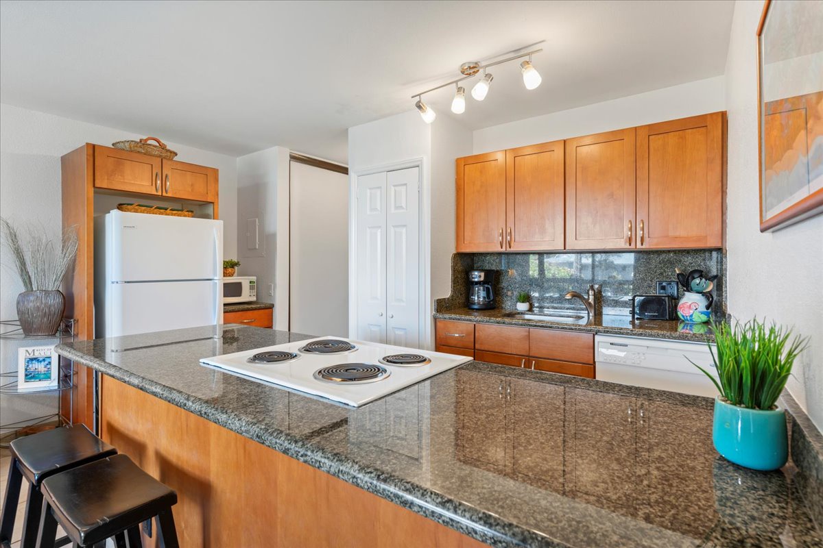 Your well-appointed kitchen invites you to cook and gather with its granite countertops, central island with electric stovetop, and plenty of cabinet space for all your culinary needs.