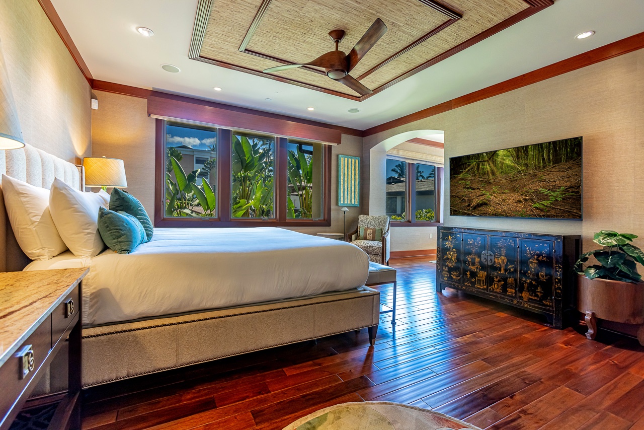 Wake up surrounded by rich hardwood floors and lush tropical views framed by elegant windows. Your serene bedroom blends island charm with refined comfort, inviting you to unwind in style.