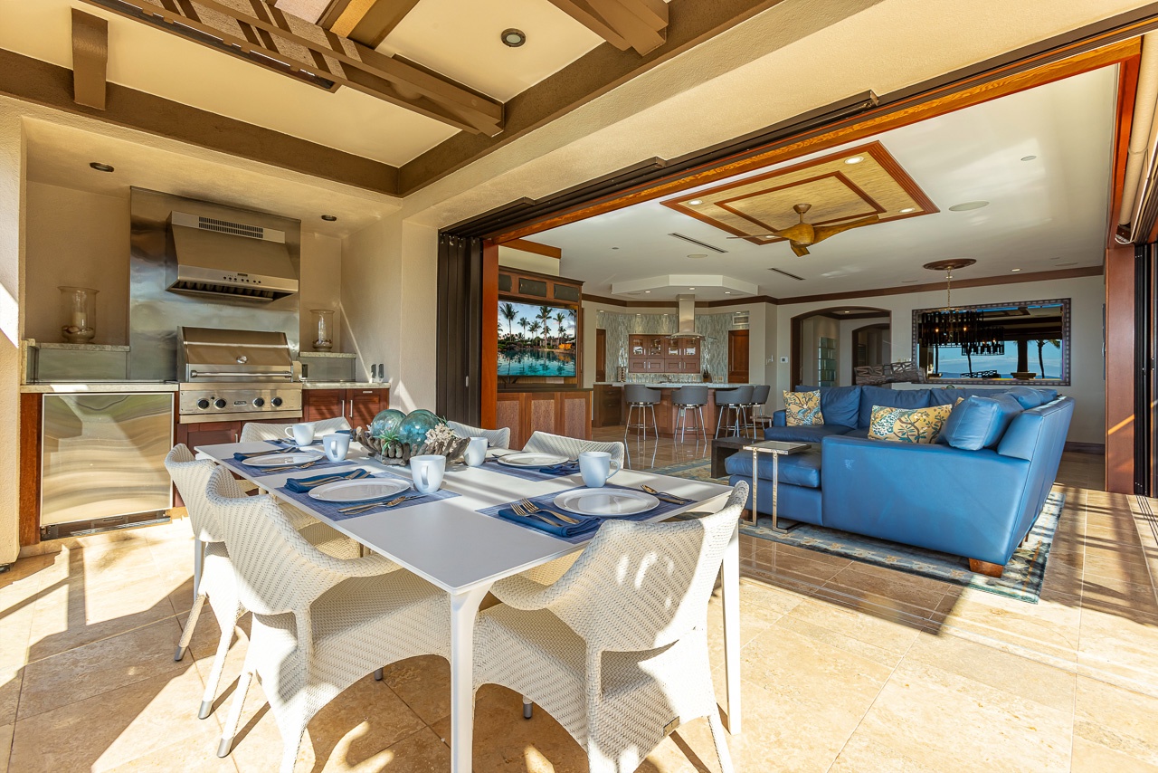 Your open-air dining space flows seamlessly into the living area, where you can savor island-style meals and ocean breezes with a backdrop of elegant beamed ceilings and coastal-inspired furnishings.