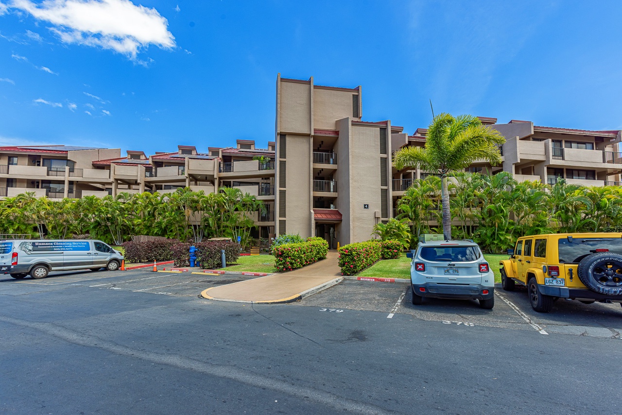 The property is surrounded by lush tropical landscaping and offers convenient parking for guests. The well-maintained grounds feature towering palms and vibrant greenery that set a relaxing vacation atmosphere from the moment of arrival.