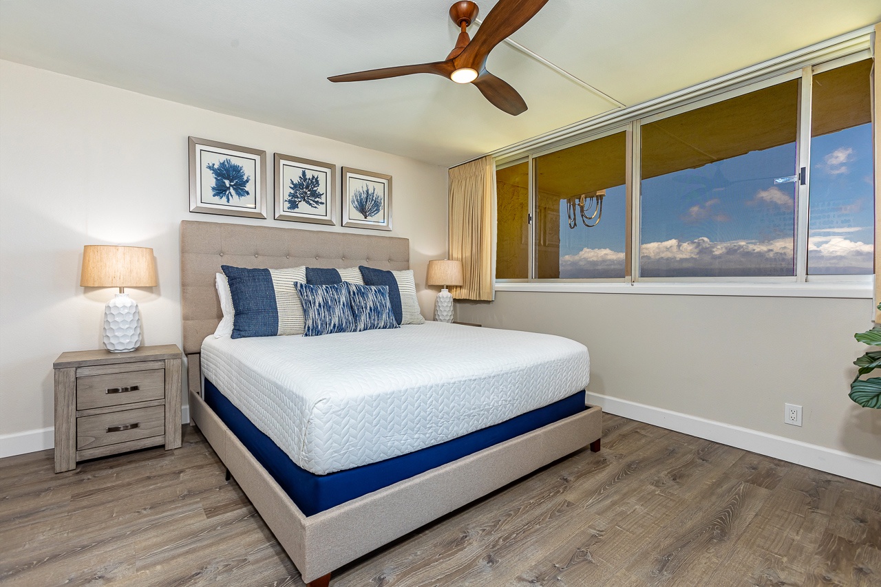 Step into your serene bedroom retreat with calming coastal blues, a plush bed, and breezy ceiling fan. Natural light fills the space while tranquil artwork sets the mood for relaxation.
