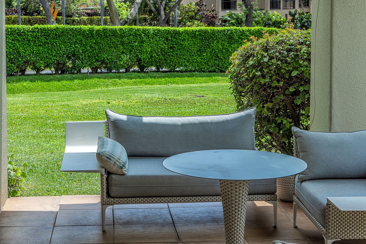 Relax on stylish wicker seating overlooking the lush garden—your serene outdoor retreat awaits.