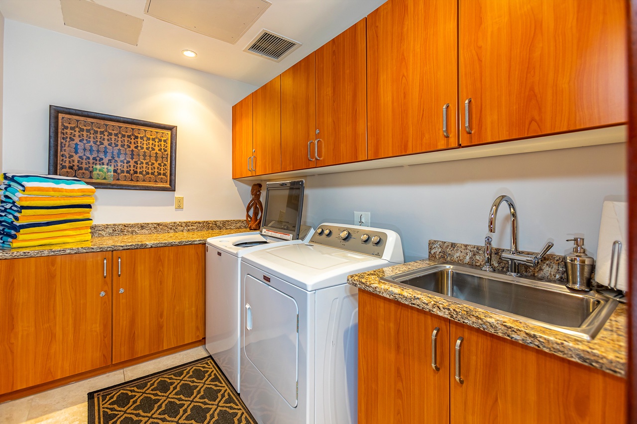 Your laundry is a breeze with a dedicated space featuring a full-size washer and dryer, gleaming sink, and plenty of storage to keep everything organized and within reach.