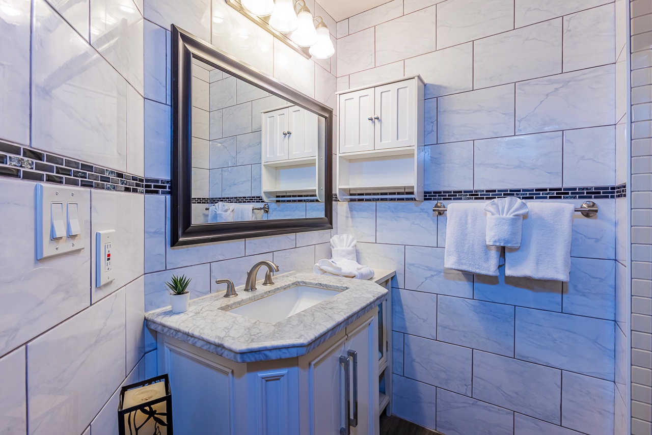 Your elegant marble bathroom features soft lighting, and fresh towels awaiting your arrival.
