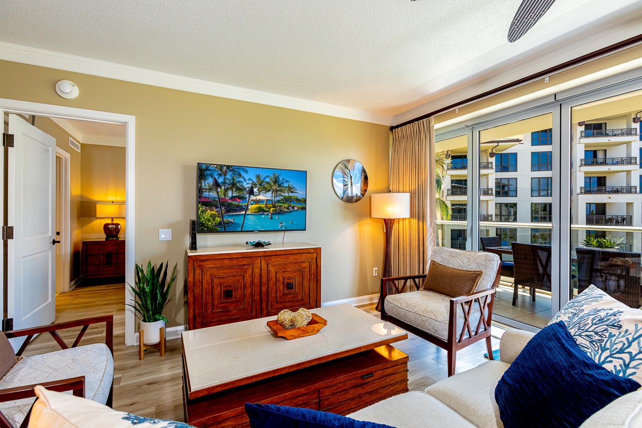 Step into your inviting living room where natural light pours in through the sliding glass doors, leading to your private balcony. Relax on plush seating and enjoy the tropical breeze.
