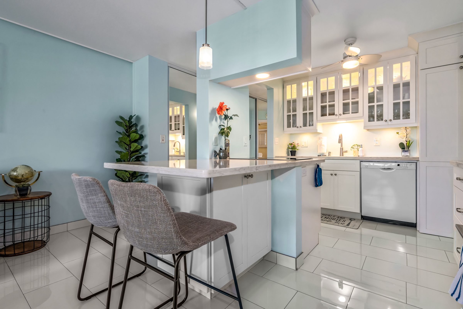 Your bright, modern kitchen features a breakfast bar perfect for morning coffee, crisp white cabinetry, stainless appliances, and soft blue walls that invite relaxation.